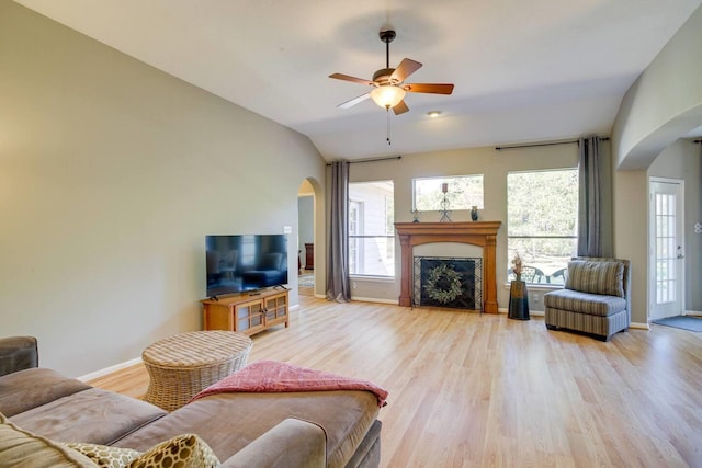 living room featuring ceiling fan, a healthy amount of sunlight, light wood-type flooring, and vaulted ceiling