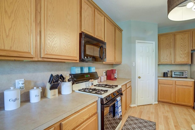 kitchen with light hardwood / wood-style floors and white range with gas stovetop