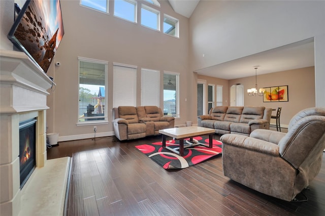 living room featuring a chandelier, a high ceiling, plenty of natural light, and dark wood-type flooring