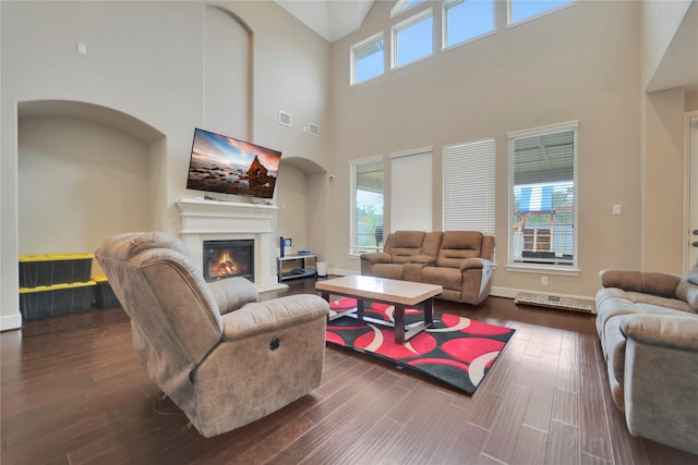 living room with dark hardwood / wood-style flooring and a towering ceiling