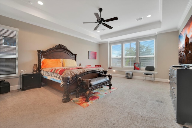 bedroom with a tray ceiling, ceiling fan, light colored carpet, and ornamental molding