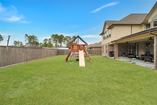 view of jungle gym with a yard, ceiling fan, and a patio area