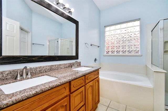 bathroom featuring plus walk in shower, vanity, and tile patterned floors