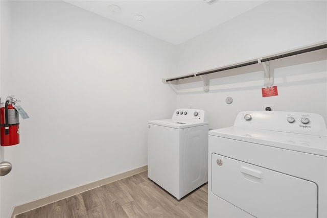 laundry room featuring light hardwood / wood-style floors and washing machine and dryer