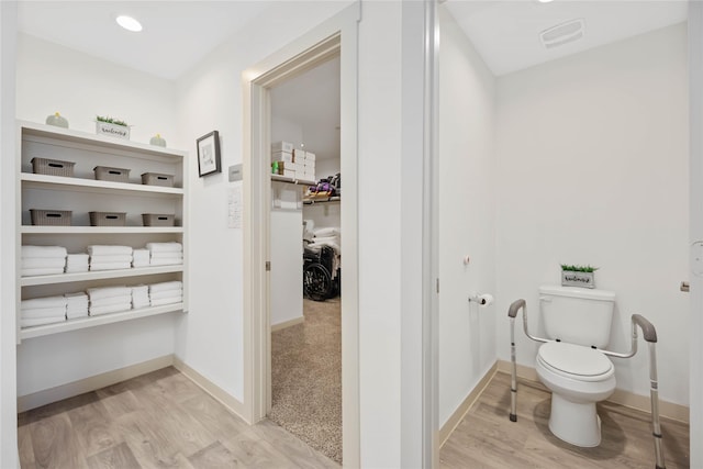 bathroom featuring toilet and wood-type flooring