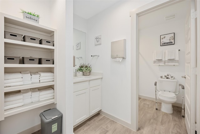 bathroom featuring hardwood / wood-style flooring, vanity, and toilet