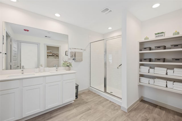 bathroom featuring vanity, hardwood / wood-style flooring, and a shower with door