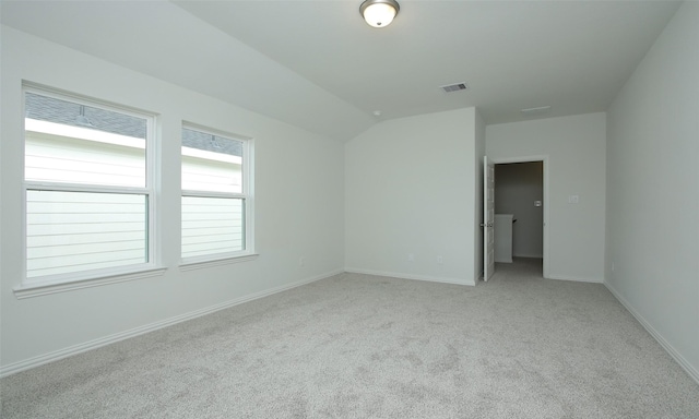 carpeted empty room featuring lofted ceiling