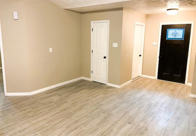 entryway with light hardwood / wood-style floors and a textured ceiling