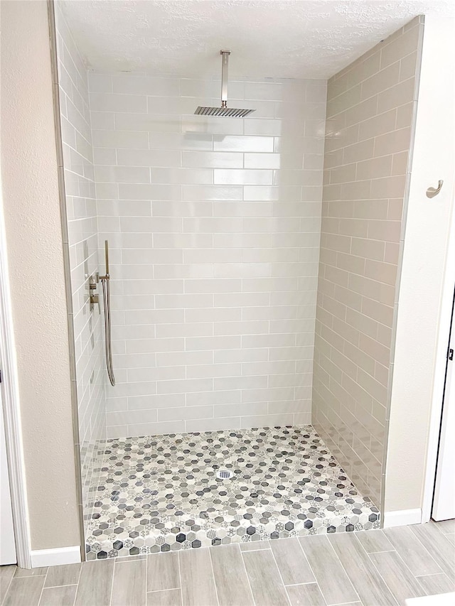 bathroom featuring tiled shower and a textured ceiling