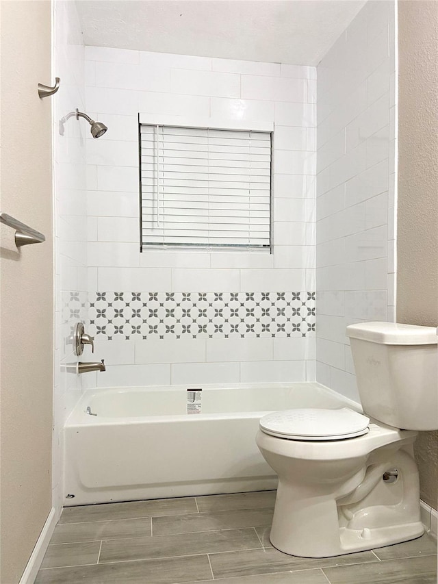 bathroom featuring toilet and tiled shower / bath combo