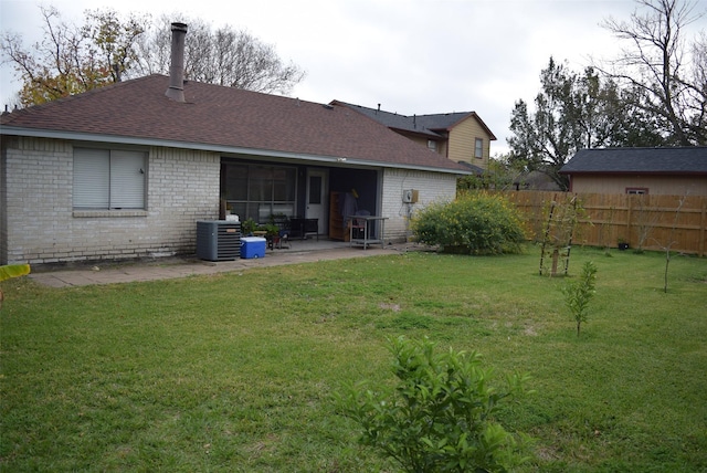 rear view of house with a patio, central AC, and a lawn