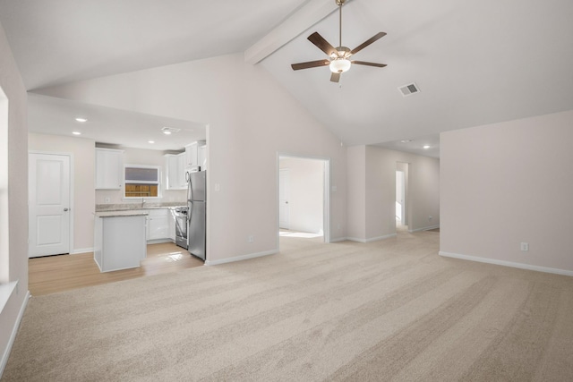 unfurnished living room featuring beamed ceiling, light colored carpet, high vaulted ceiling, and ceiling fan