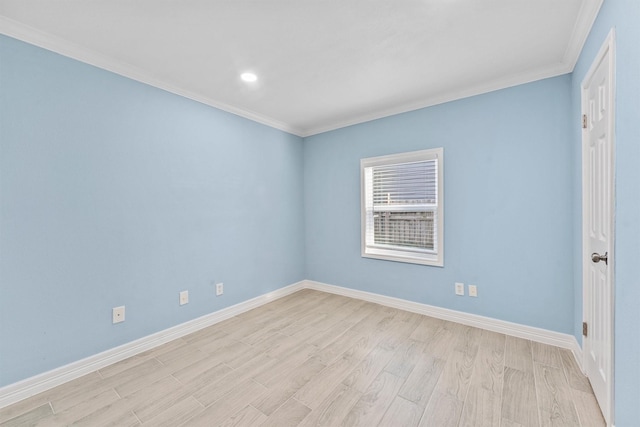 spare room with ornamental molding and light hardwood / wood-style flooring