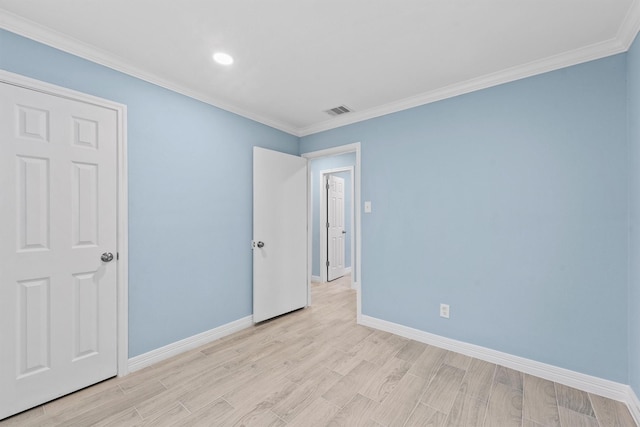 spare room featuring light hardwood / wood-style floors and ornamental molding