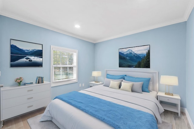 bedroom featuring light wood-type flooring and crown molding