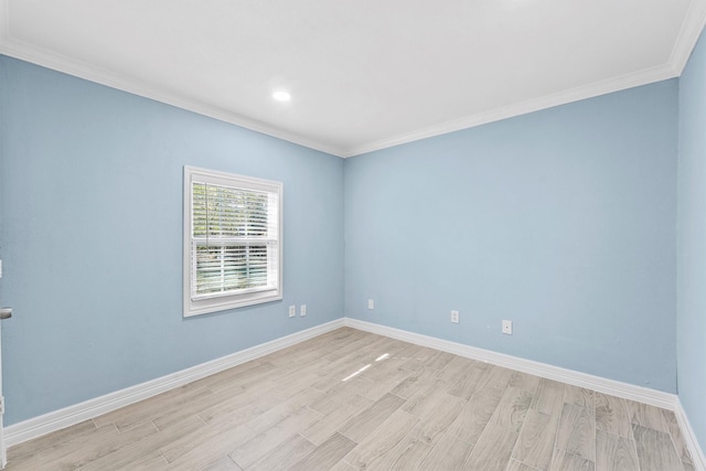 spare room featuring ornamental molding and light hardwood / wood-style flooring