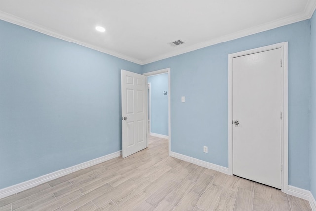 spare room featuring light hardwood / wood-style floors and crown molding