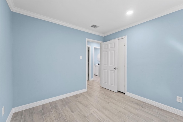 empty room featuring light hardwood / wood-style flooring and crown molding