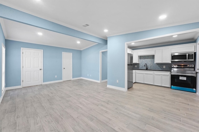 kitchen featuring backsplash, light hardwood / wood-style flooring, white cabinets, and stainless steel appliances