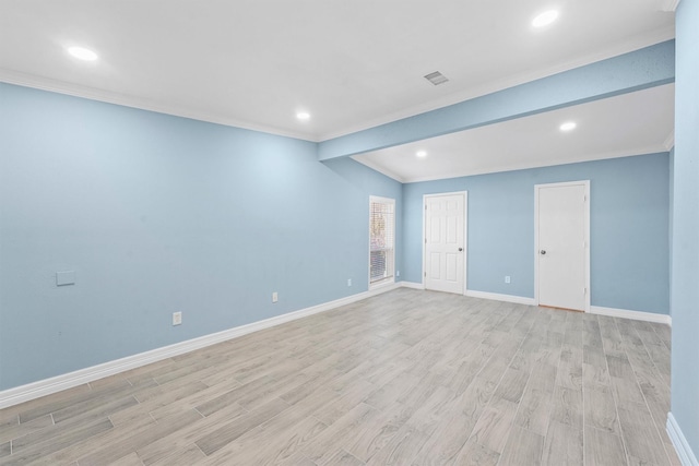 unfurnished room featuring light hardwood / wood-style floors, lofted ceiling, and ornamental molding