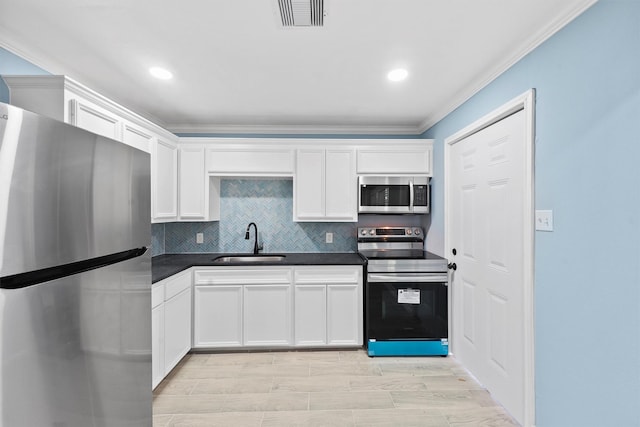 kitchen featuring sink, stainless steel appliances, tasteful backsplash, crown molding, and white cabinets