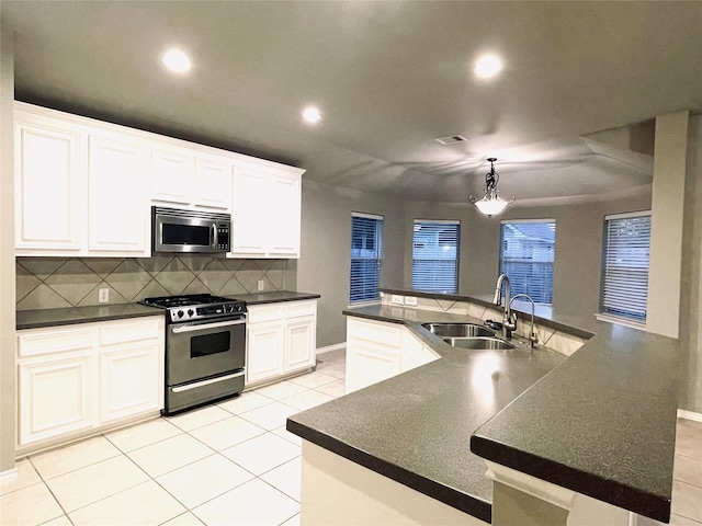 kitchen featuring sink, stainless steel appliances, a kitchen island with sink, and tasteful backsplash