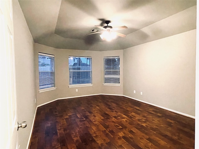 empty room featuring hardwood / wood-style flooring, ceiling fan, and a tray ceiling