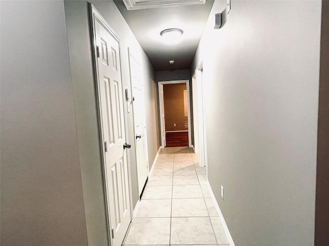 hall featuring light tile patterned floors and ornamental molding