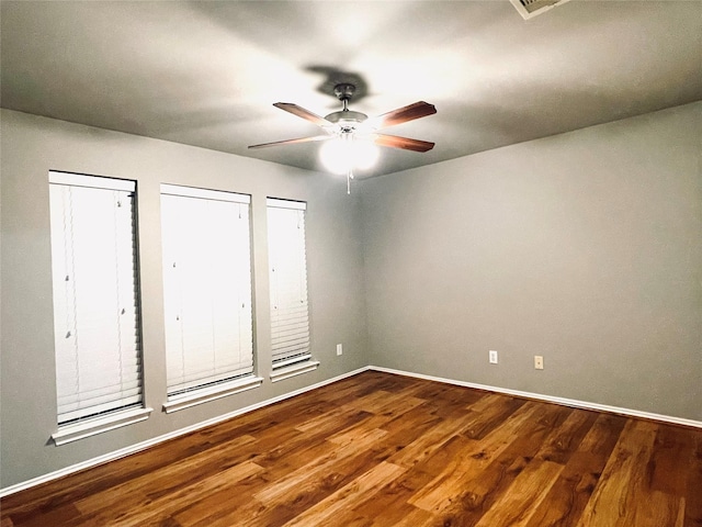 unfurnished bedroom with ceiling fan, hardwood / wood-style floors, and two closets