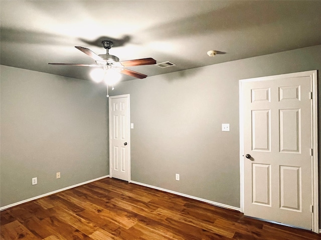 empty room featuring dark hardwood / wood-style flooring and ceiling fan