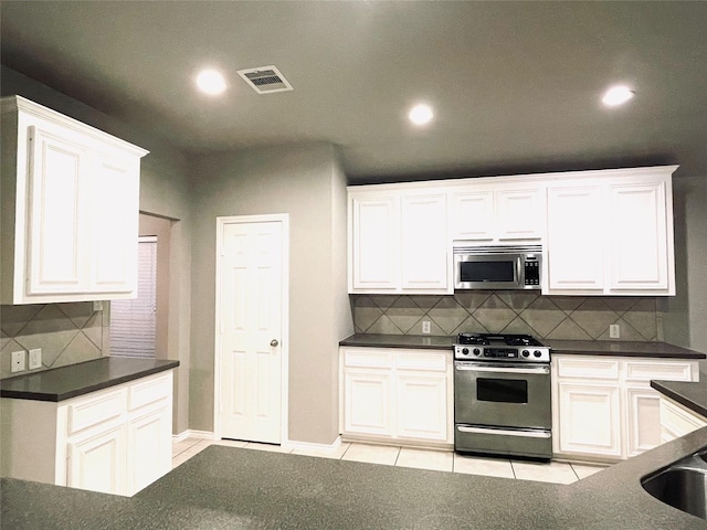 kitchen with backsplash, light tile patterned flooring, white cabinetry, and stainless steel appliances