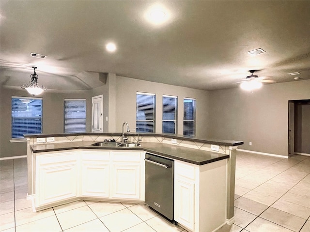 kitchen featuring decorative light fixtures, sink, white cabinetry, and an island with sink