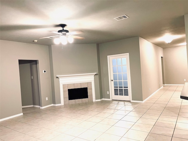 unfurnished living room featuring light tile patterned floors, ceiling fan, and a tiled fireplace