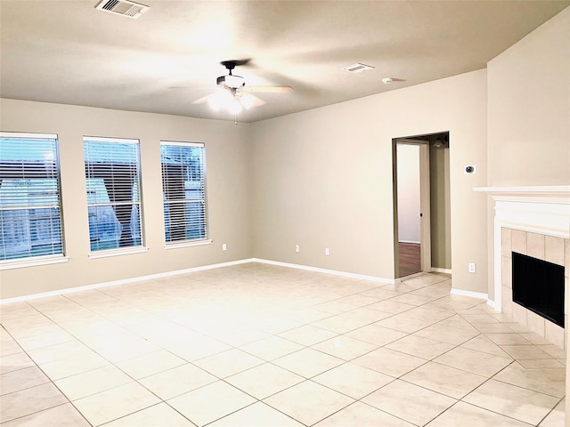 unfurnished living room featuring a tile fireplace, light tile patterned floors, and ceiling fan