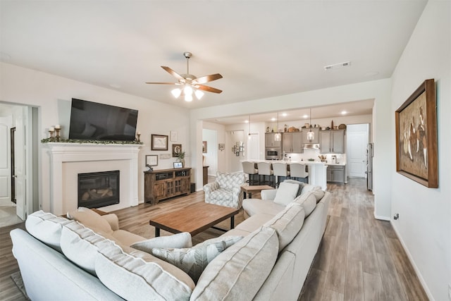 living room featuring ceiling fan and light wood-type flooring