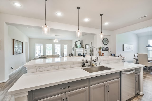 kitchen featuring sink, hanging light fixtures, stainless steel dishwasher, ceiling fan, and hardwood / wood-style flooring