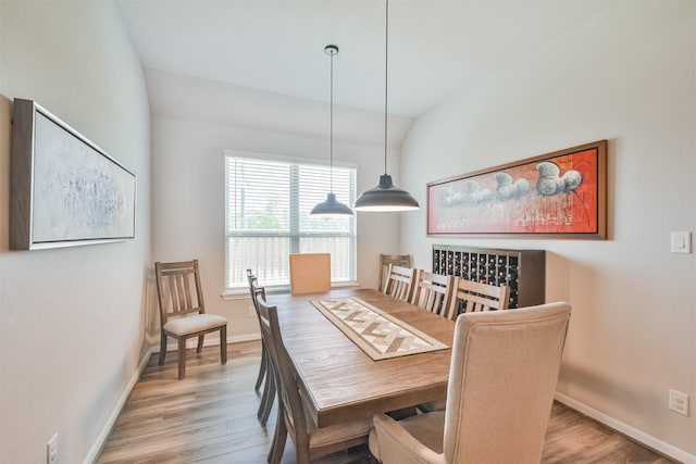 dining room with lofted ceiling and light hardwood / wood-style flooring