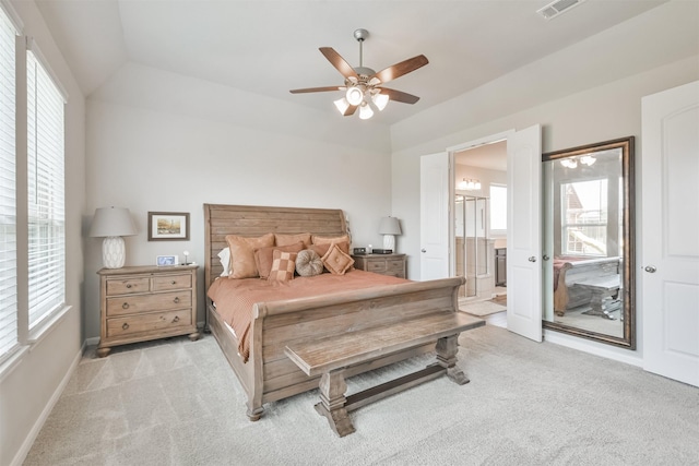 carpeted bedroom with vaulted ceiling, ensuite bath, and ceiling fan