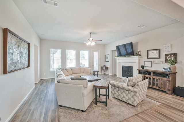 living room featuring ceiling fan and light hardwood / wood-style floors