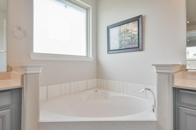 bathroom with vanity and a washtub