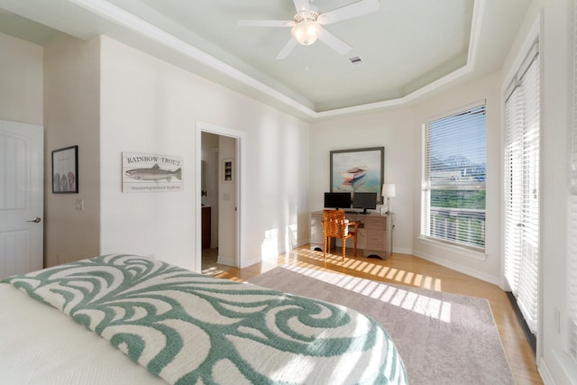 bedroom featuring a tray ceiling, ceiling fan, and hardwood / wood-style floors