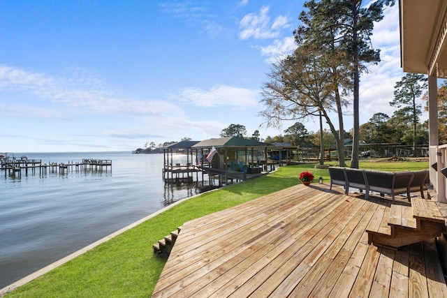 view of dock with a yard and a water view