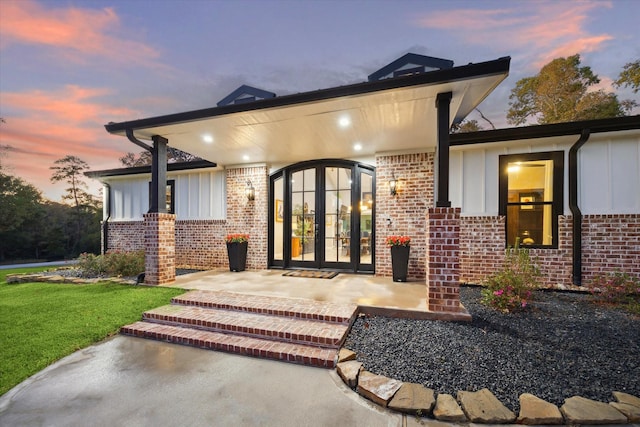 exterior entry at dusk featuring a patio area and french doors