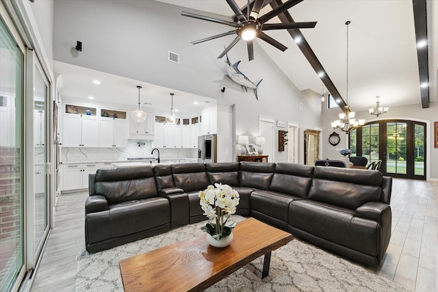 living room with beamed ceiling, ceiling fan with notable chandelier, and high vaulted ceiling