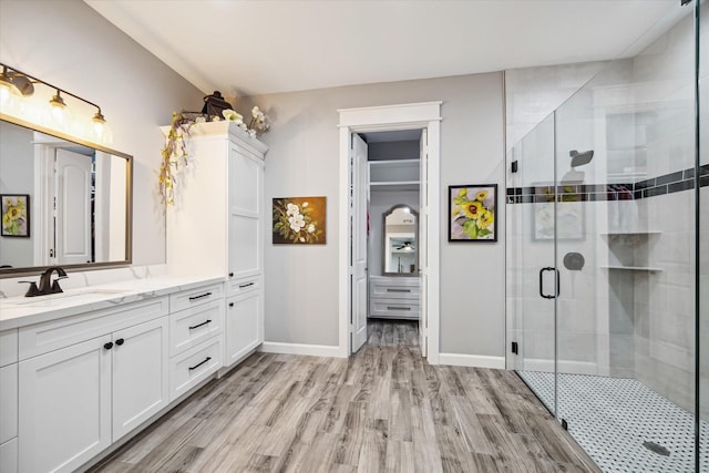 bathroom with hardwood / wood-style flooring, vanity, and walk in shower