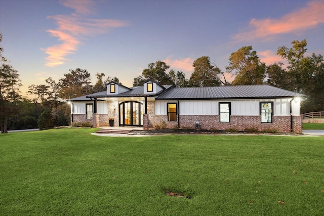 view of front of home with a yard and french doors