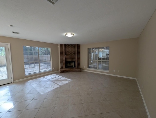 unfurnished living room featuring a textured ceiling, light tile patterned floors, and a fireplace