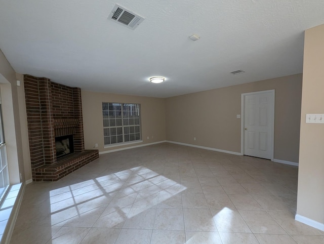 unfurnished living room featuring a textured ceiling, light tile patterned floors, and a fireplace