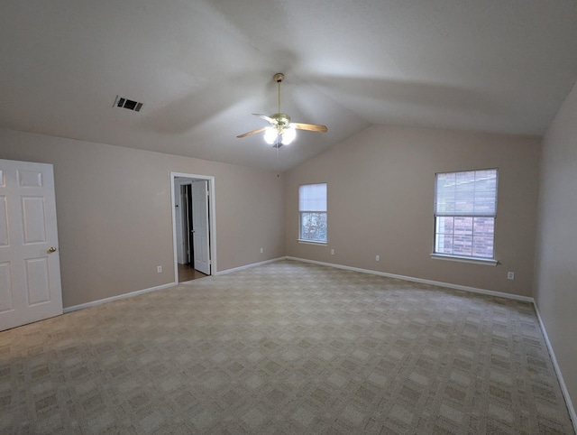 unfurnished room featuring ceiling fan, a healthy amount of sunlight, vaulted ceiling, and light colored carpet